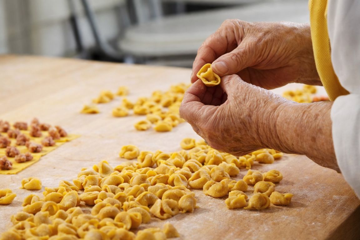Le sfogline hand-crafting fresh tortellini pasta in Bologna during a Bologna Italy Food Tours culinary experience